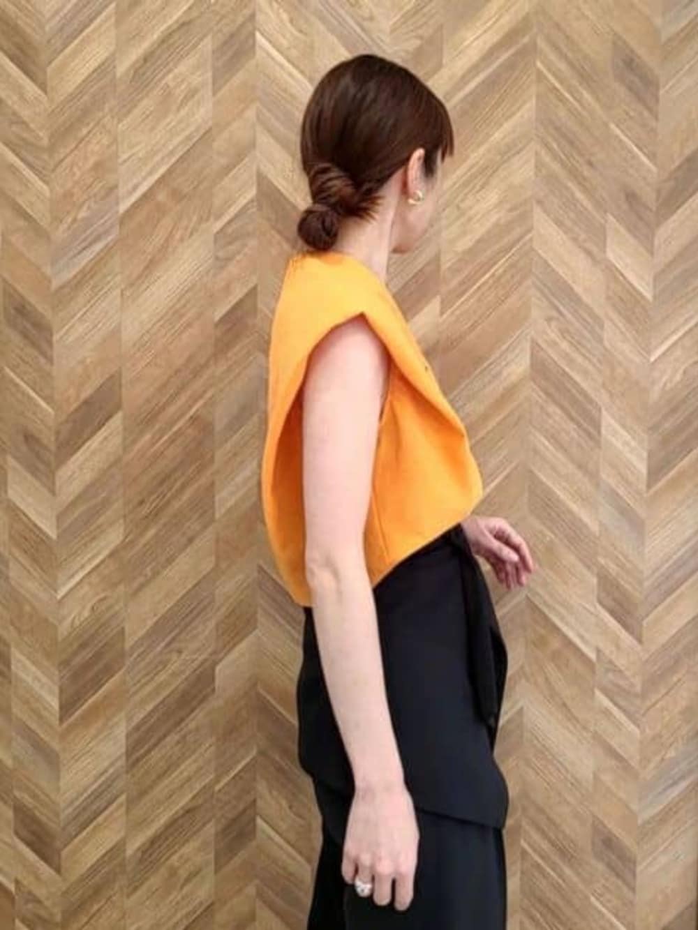 ブラック系のその他パンツ、オレンジ系のワンピースを着用したレディースの冬コーディネートの5枚目の写真