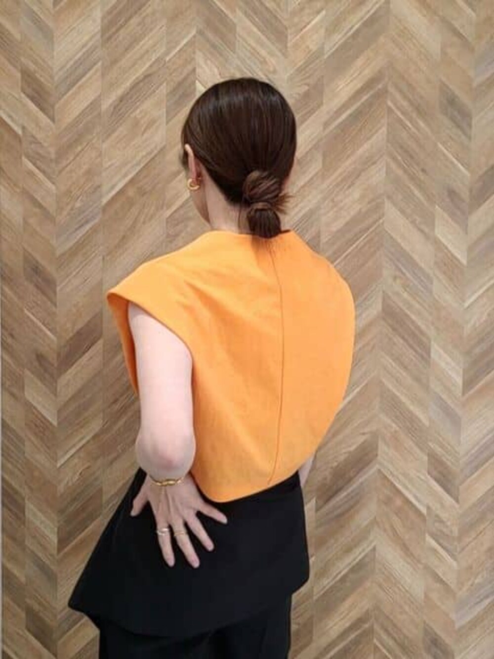 ブラック系のその他パンツ、オレンジ系のワンピースを着用したレディースの冬コーディネートの7枚目の写真