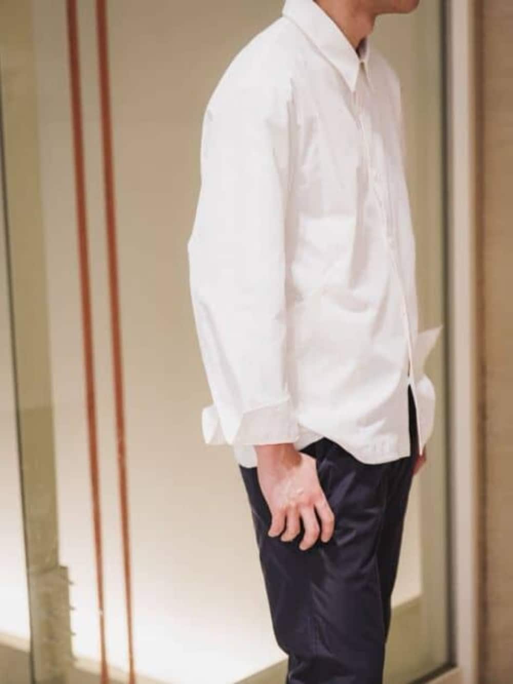 ホワイト系のテーラードジャケット、ブルー系のスラックスを着用したメンズの春コーディネートの6枚目の写真