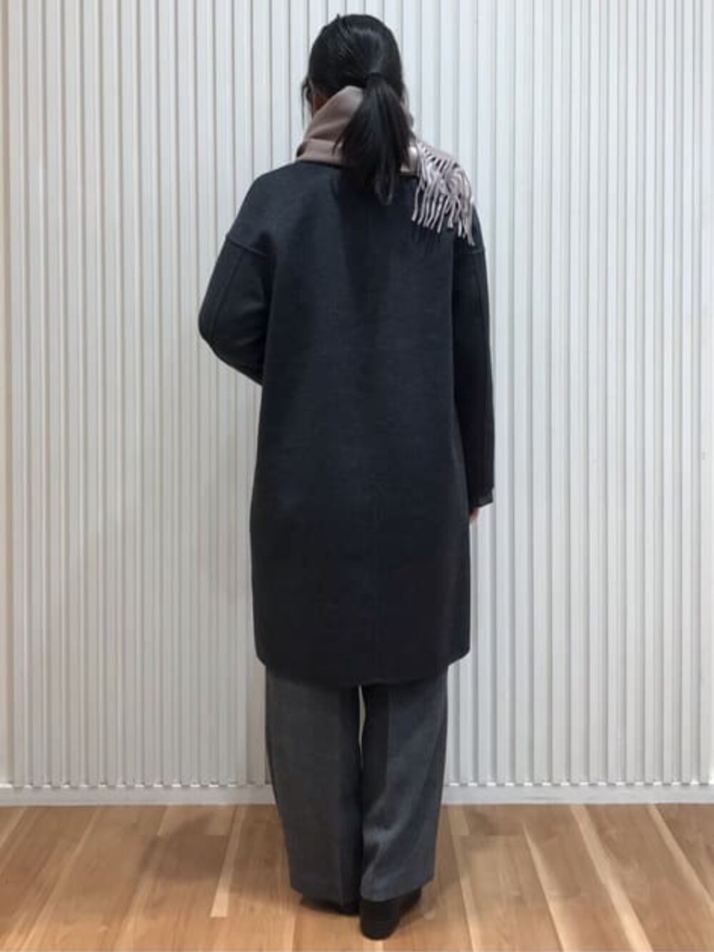 グレー系のピーコートを着用したレディースの冬コーディネートの3枚目の写真