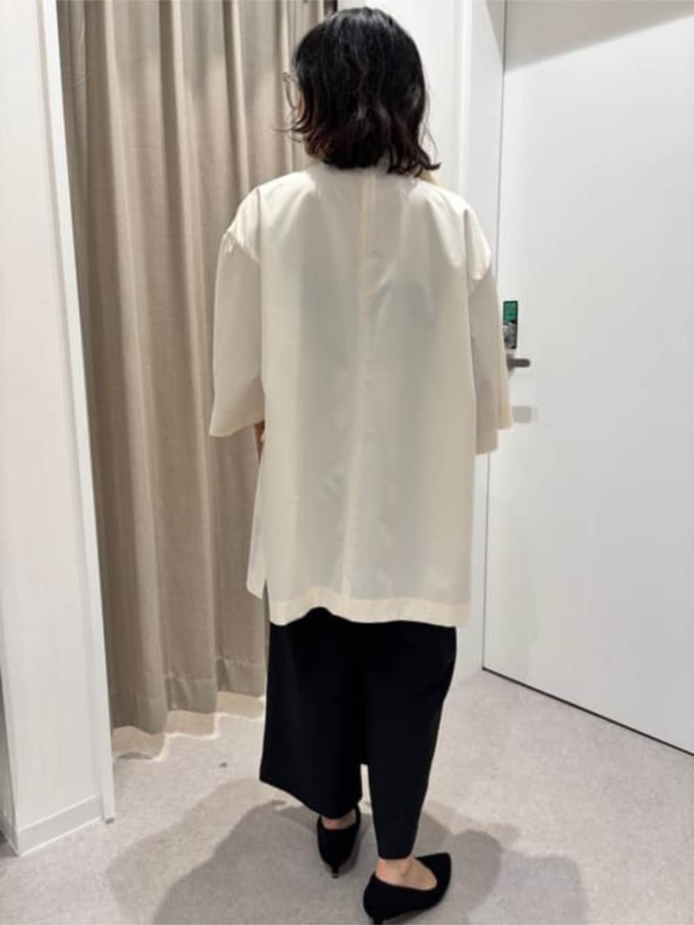 ブラック系のワンピース、ホワイト系のその他アウターを着用したレディースの冬コーディネートの6枚目の写真