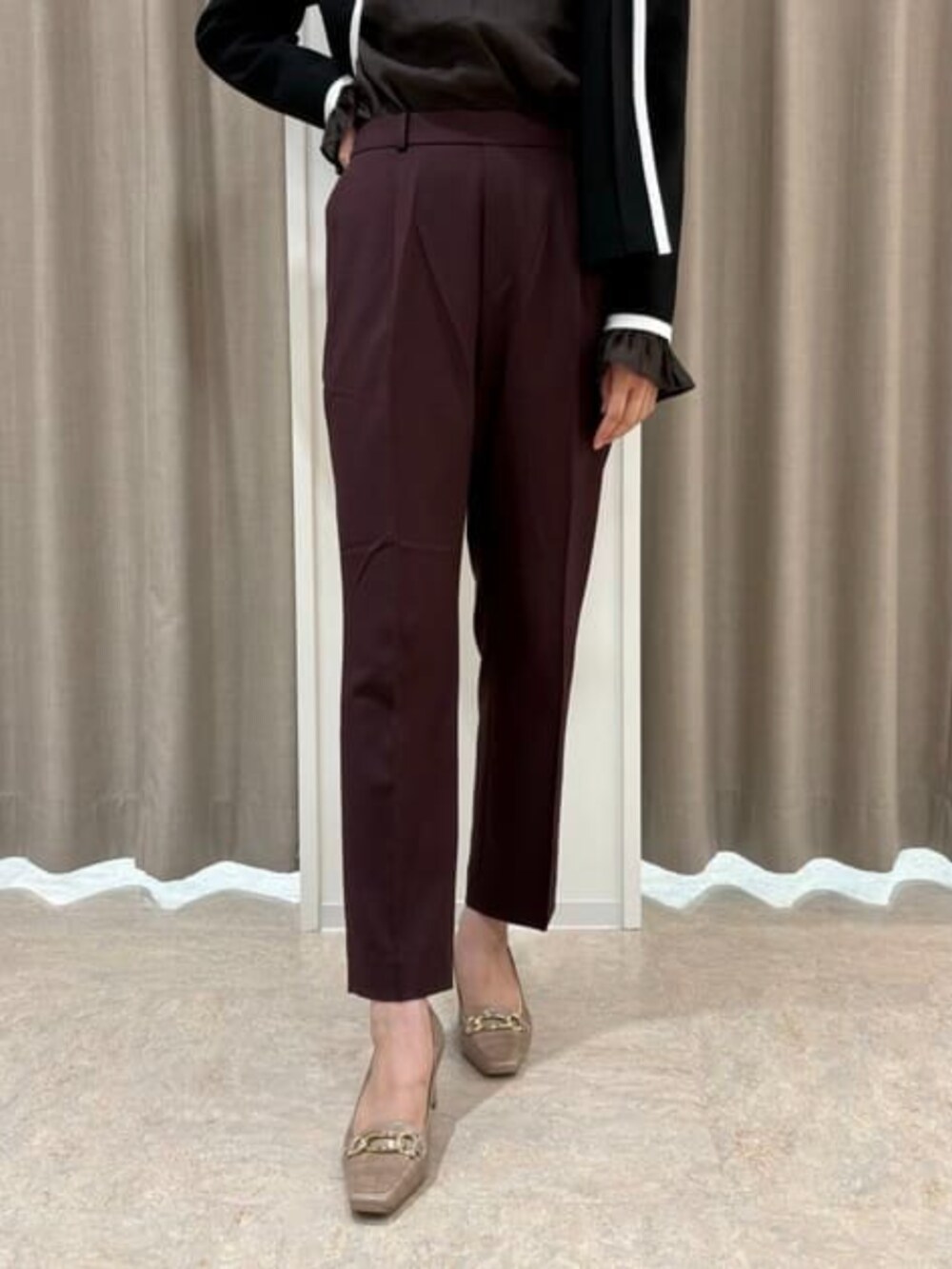 パープル系のスラックス、ブラウン系のシャツ/ブラウス、ブラック系のニット/セーターを着用したレディースの冬コーディネートの3枚目の写真