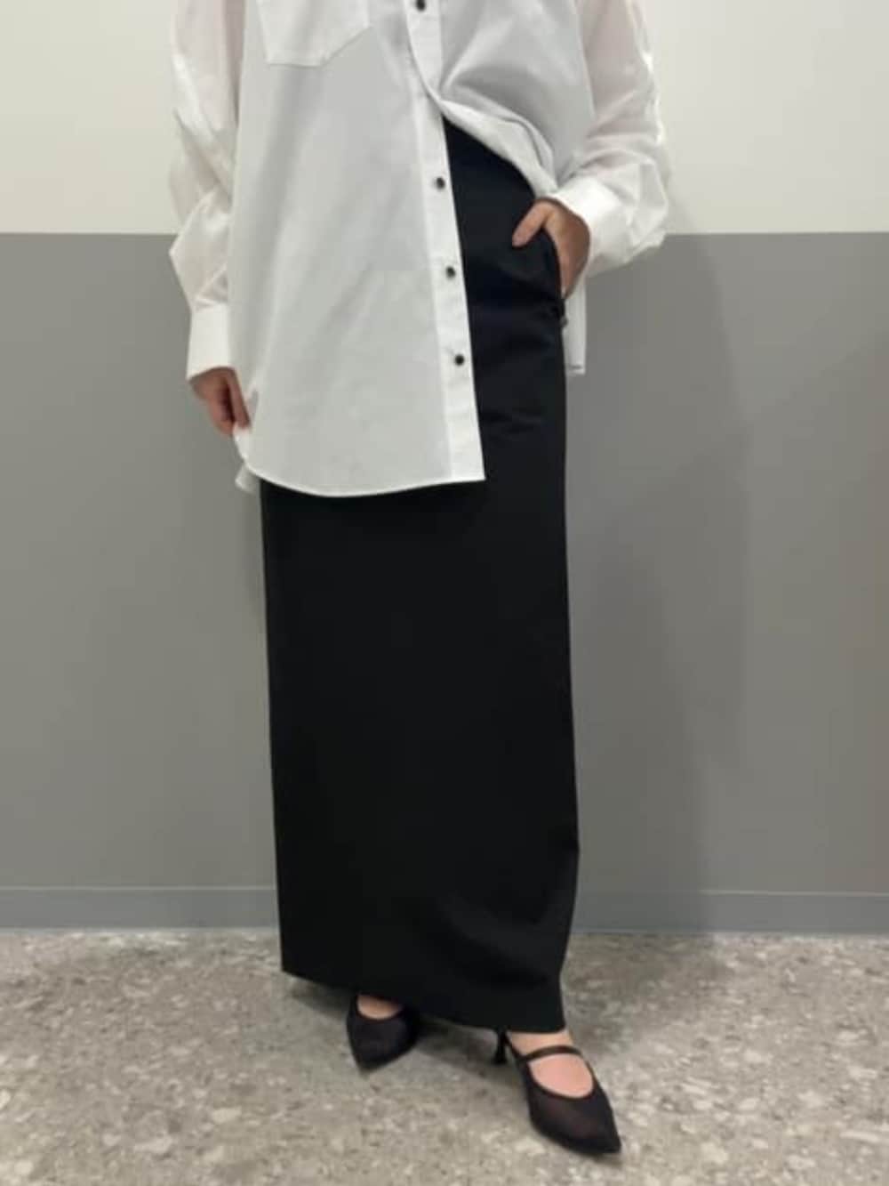 ホワイト系のシャツ/ブラウス、ブラック系のスカート、ブラック系のベストを着用したレディースの冬コーディネートの6枚目の写真