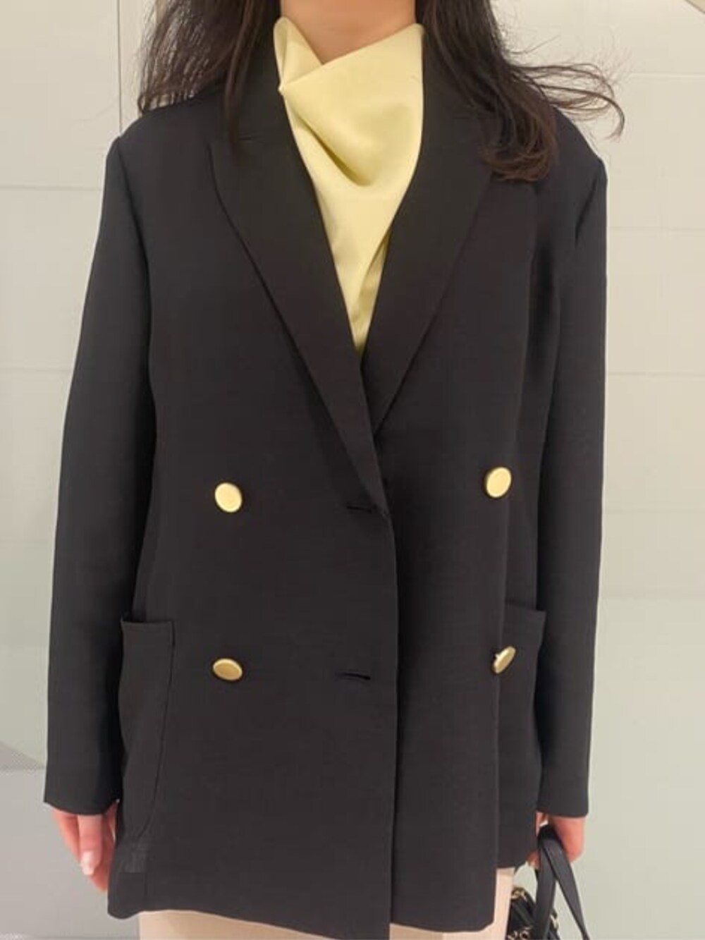 ブラック系のテーラードジャケット、イエロー系のシャツ/ブラウスを着用したレディースの春コーディネートの3枚目の写真