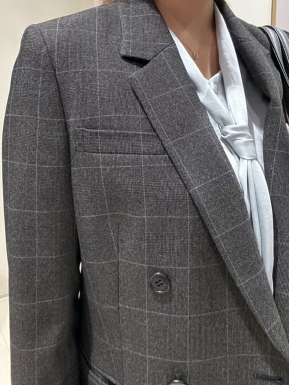 グレー系のテーラードジャケット、グレー系のスラックス、ブルー系のシャツ/ブラウスを着用したレディースの冬コーディネートの3枚目の写真