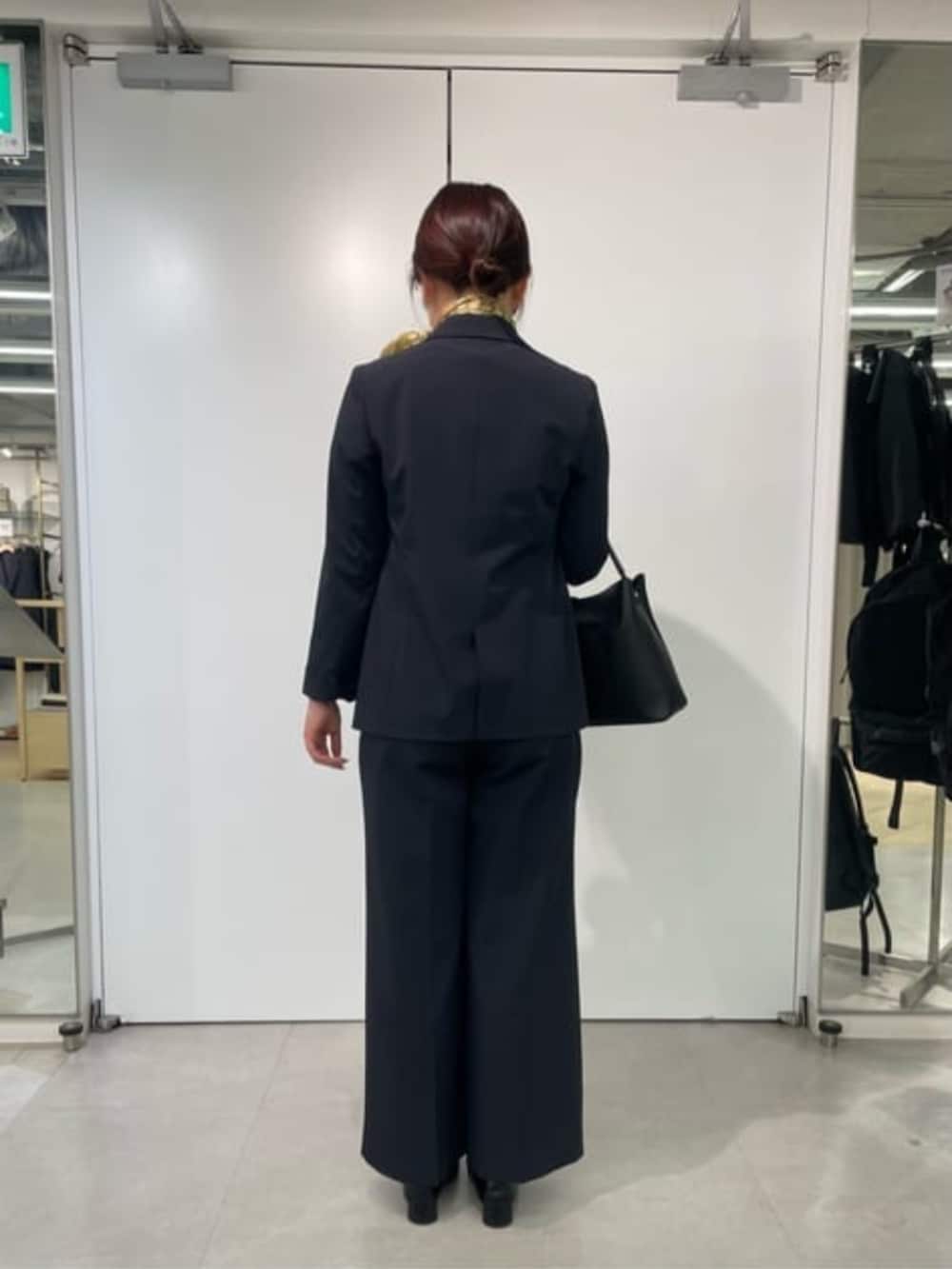 イエロー系のシャツ/ブラウス、ブルー系のテーラードジャケット、ブラック系のスラックスを着用したレディースの冬コーディネートの3枚目の写真