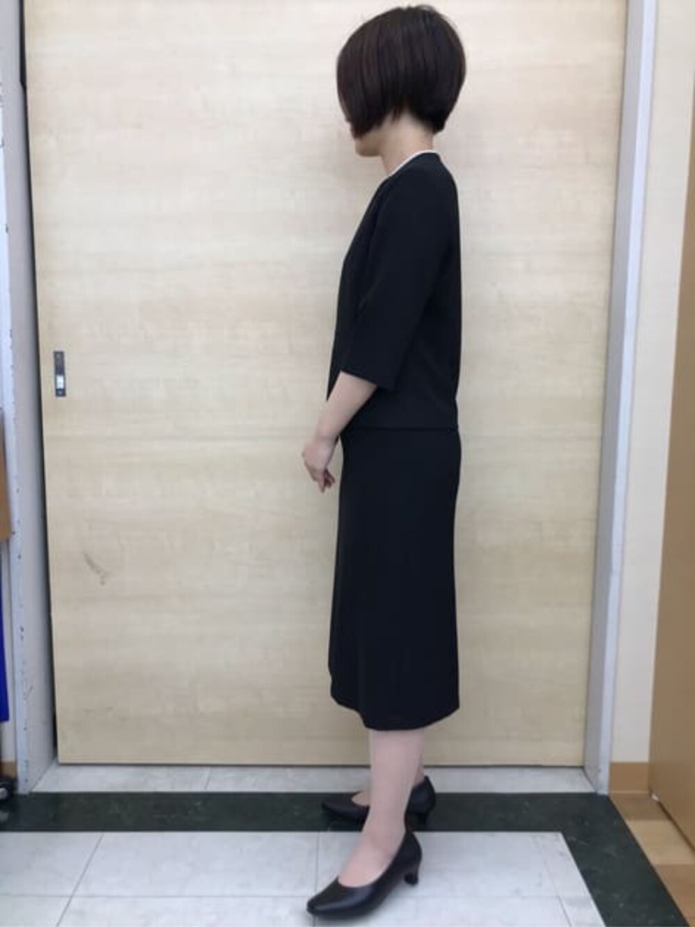 ブラック系のスーツセットを着用したレディースの冬コーディネートの6枚目の写真