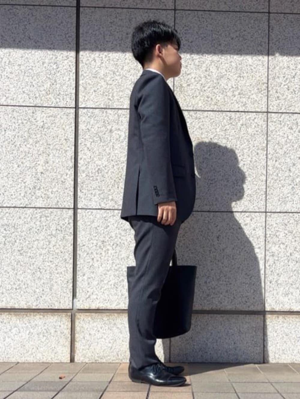 グレー系のスーツパンツを着用したメンズの冬コーディネートの3枚目の写真