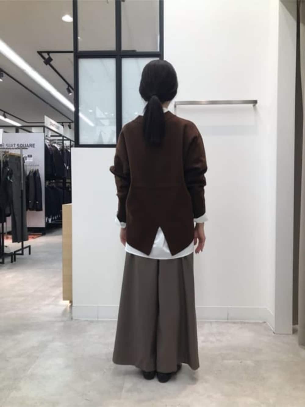 ブラウン系のニット/セーター、グリーン系のスラックス、ホワイト系のシャツ/ブラウスを着用したレディースの冬コーディネートの3枚目の写真