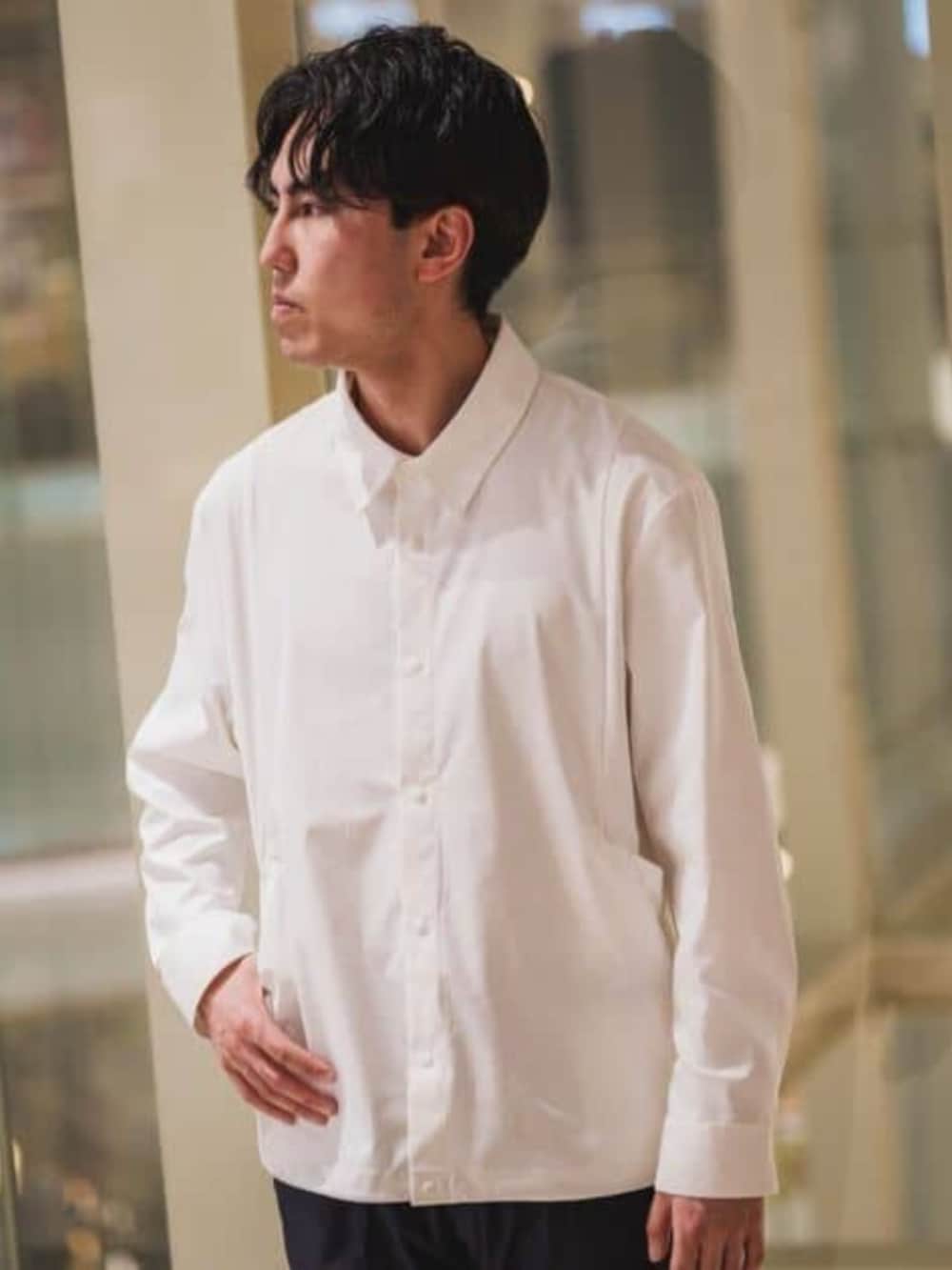 ホワイト系のテーラードジャケット、ブルー系のスラックスを着用したメンズの春コーディネートの3枚目の写真