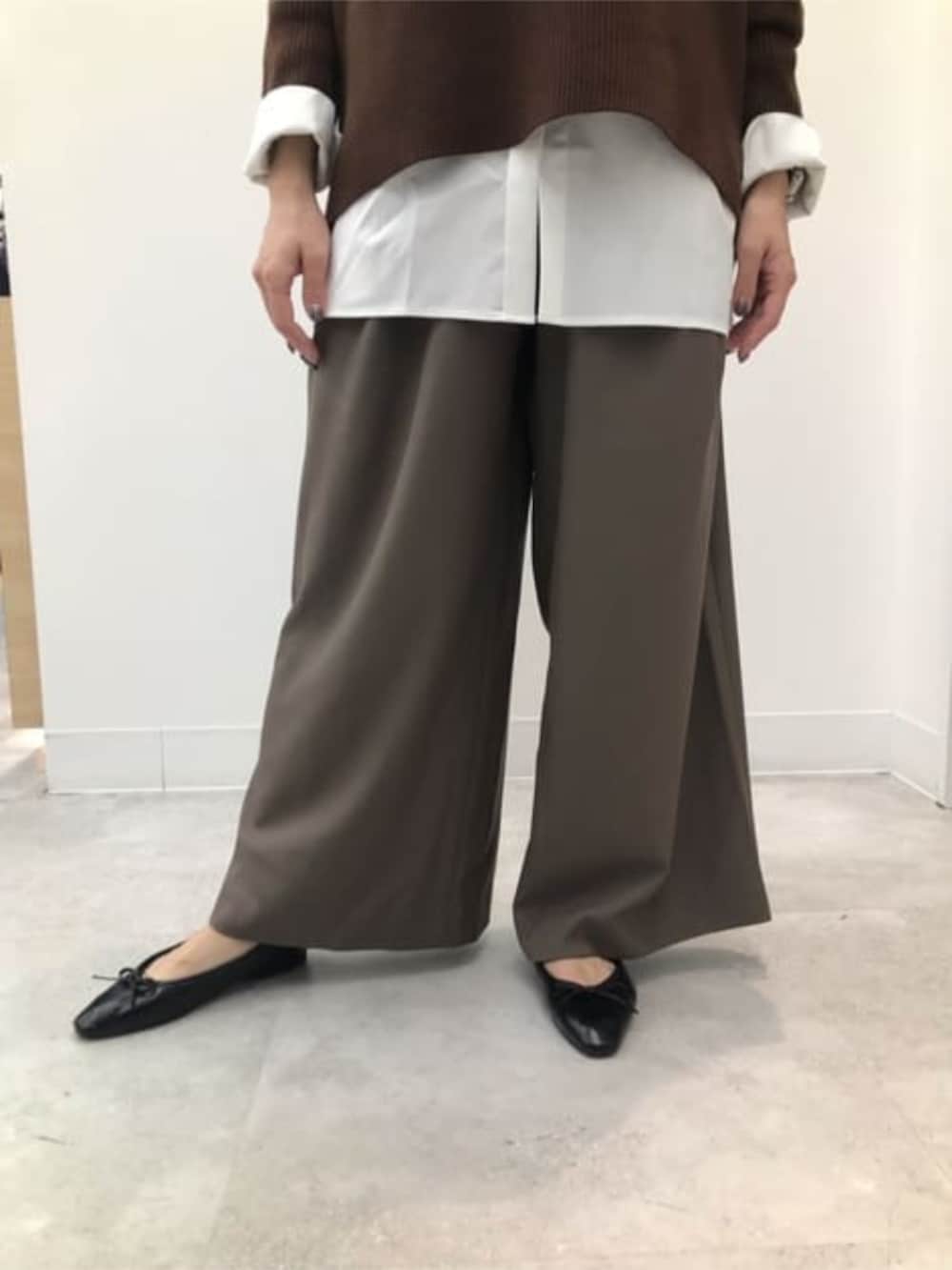 ブラウン系のニット/セーター、グリーン系のスラックス、ホワイト系のシャツ/ブラウスを着用したレディースの冬コーディネートの4枚目の写真