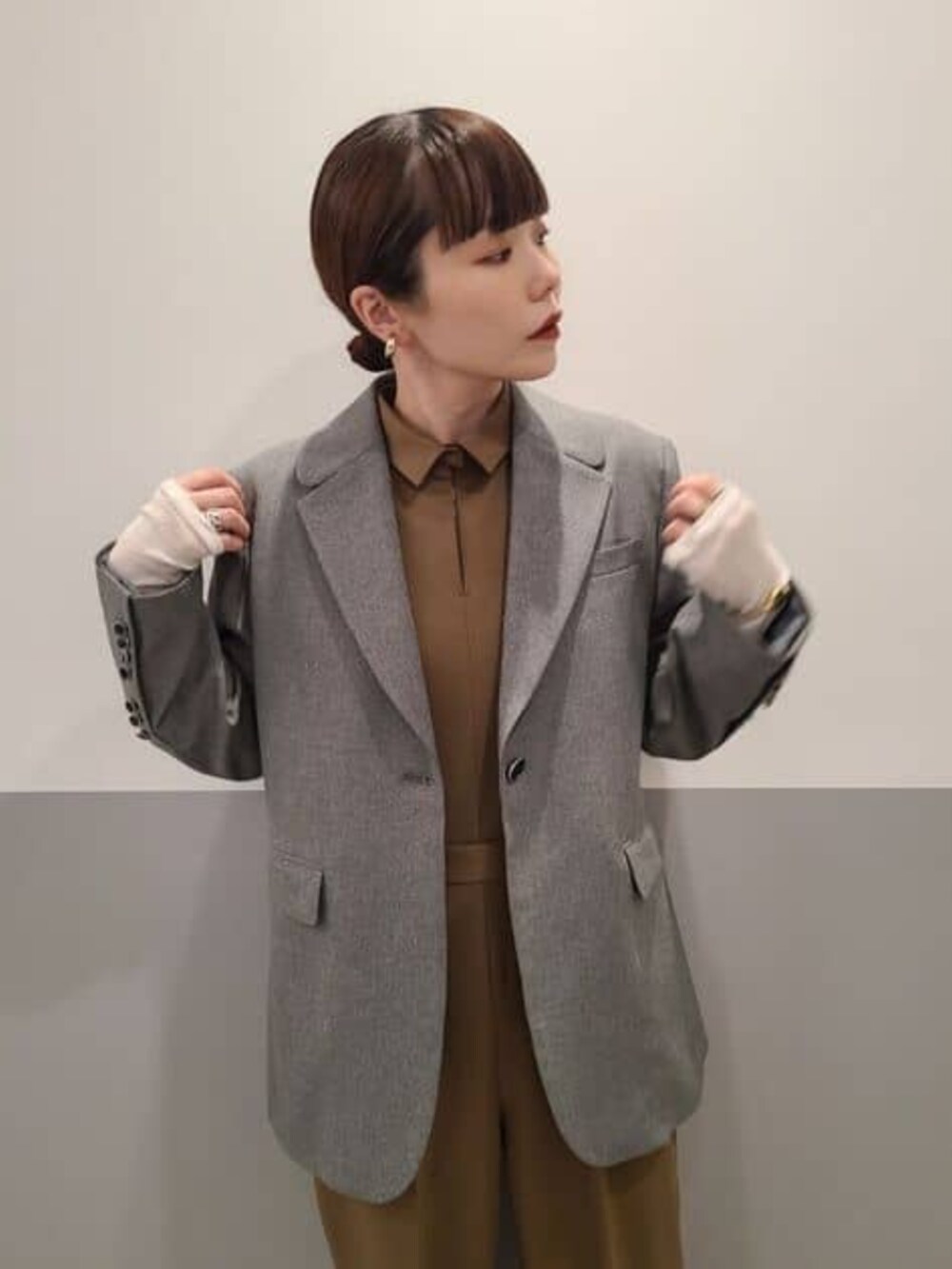 グレー系のテーラードジャケット、ベージュ系のつなぎ/オールインワンを着用したレディースの冬コーディネートの7枚目の写真