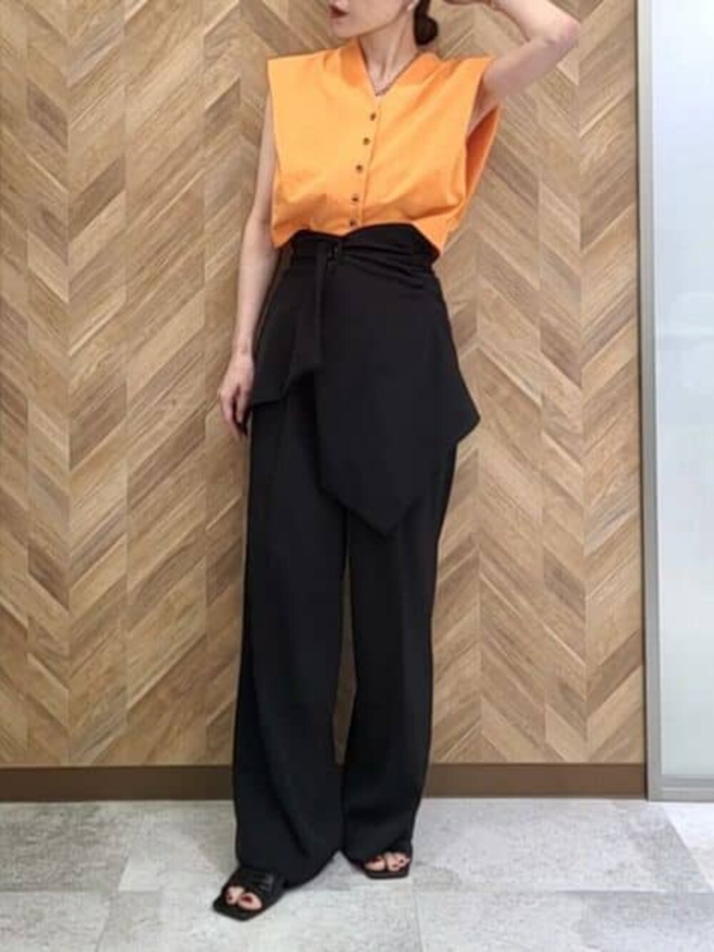 ブラック系のその他パンツ、オレンジ系のワンピースを着用したレディースの冬コーディネートの2枚目の写真