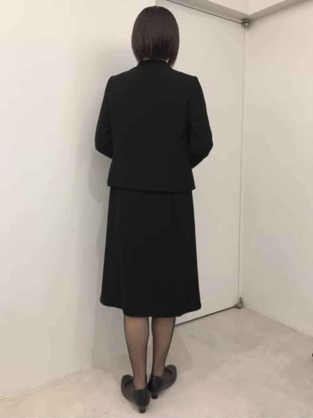 ブラック系のスーツセットを着用したレディースの冬コーディネートの2枚目の写真