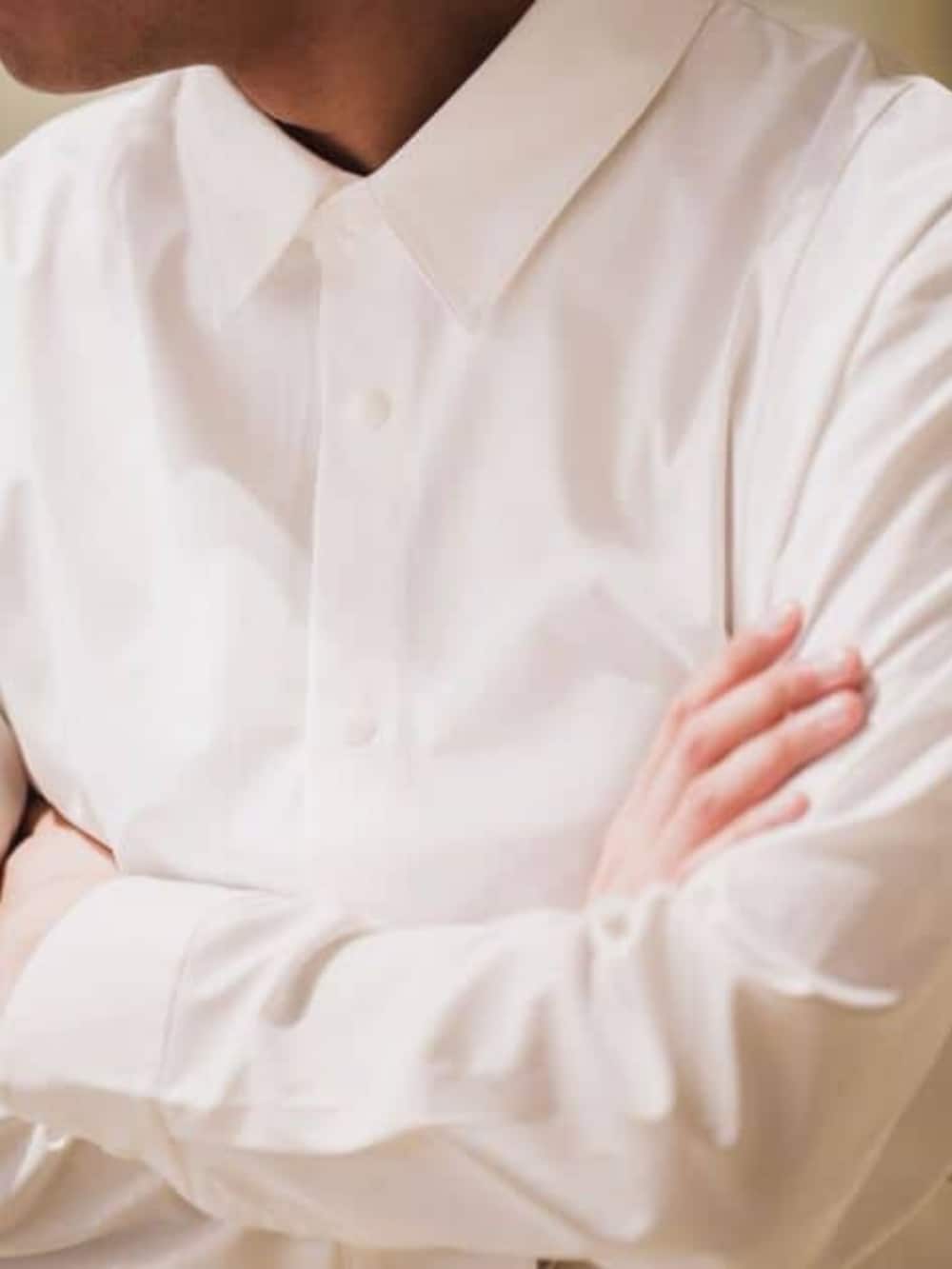 ホワイト系のテーラードジャケット、ブルー系のスラックスを着用したメンズの春コーディネートの4枚目の写真