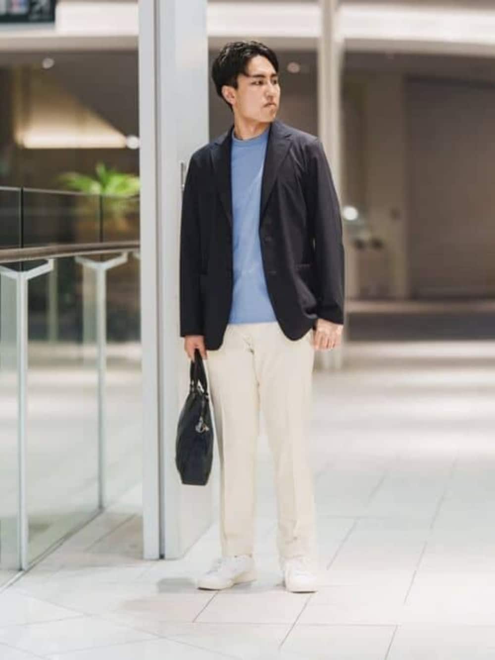 ブルー系のビジネスバッグ、ホワイト系のスラックスを着用したメンズの春コーディネートの3枚目の写真