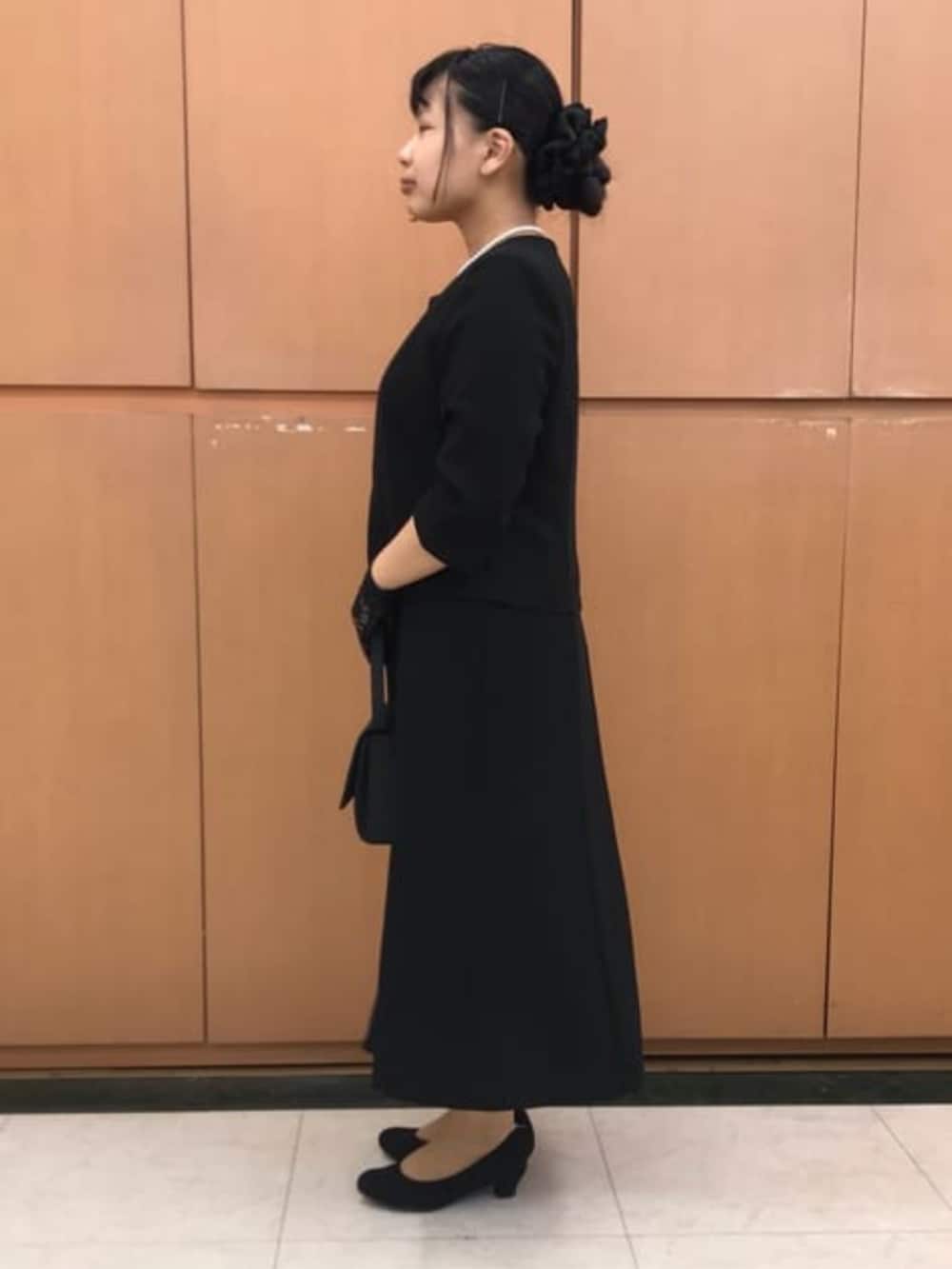 ブラック系のスーツセットを着用したレディースの冬コーディネートの6枚目の写真