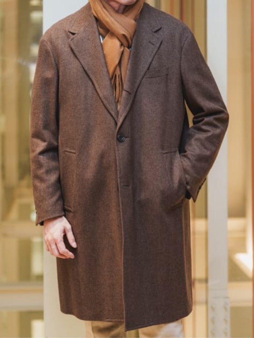 ブラウン系のチェスターコートを着用したメンズの冬コーディネートの3枚目の写真