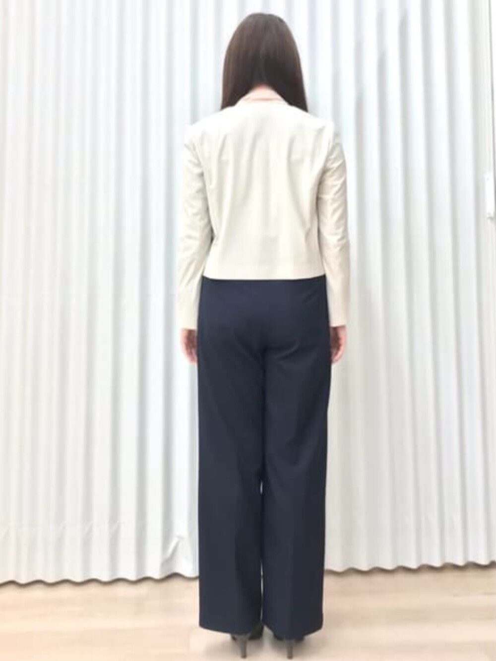 ベージュ系のスーツジャケットを着用したレディースの冬コーディネートの2枚目の写真