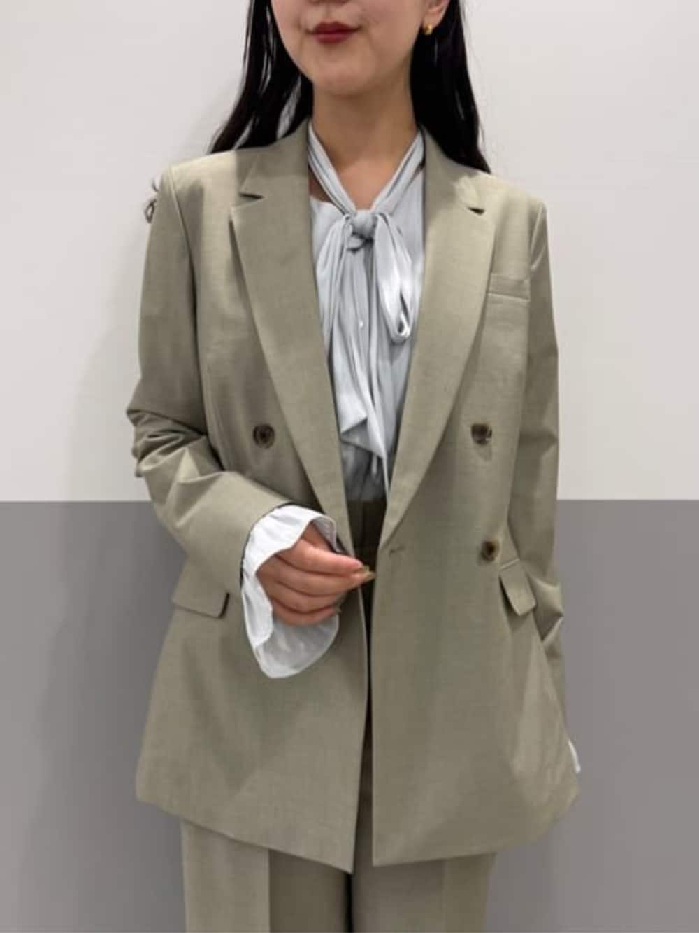 グリーン系のテーラードジャケット、グリーン系のスラックスを着用したレディースの春コーディネートの3枚目の写真