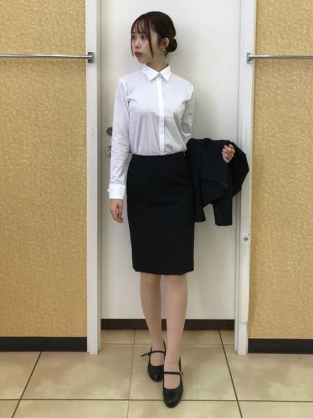 ブラック系のスーツジャケット、ブラック系のスーツスカートを着用したレディースの冬コーディネートの8枚目の写真