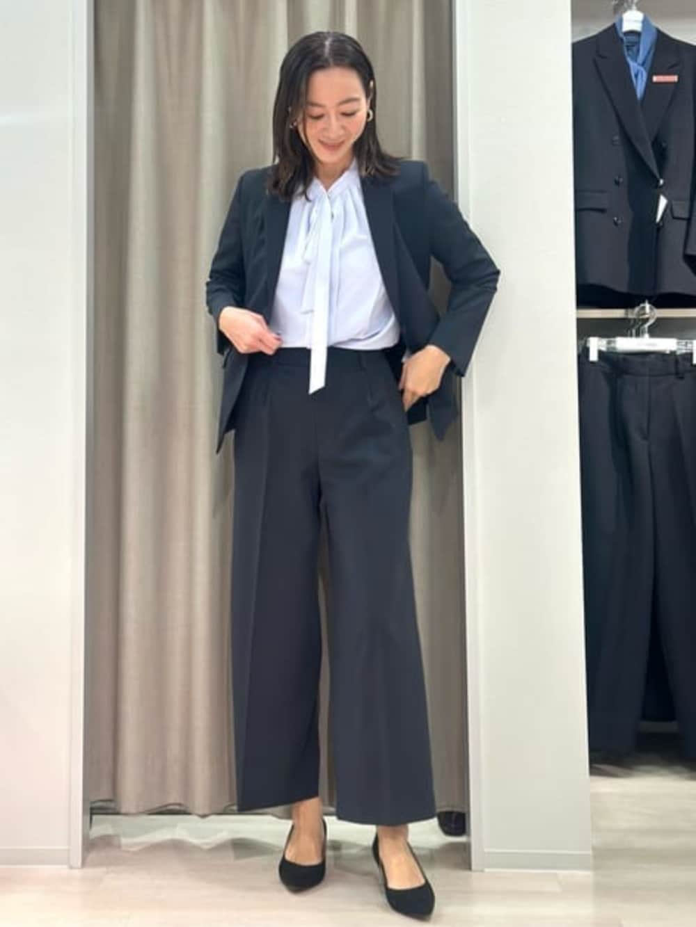 パープル系のシャツ/ブラウス、ブラック系のテーラードジャケット、ブラック系のスラックスを着用したレディースの冬コーディネートの6枚目の写真