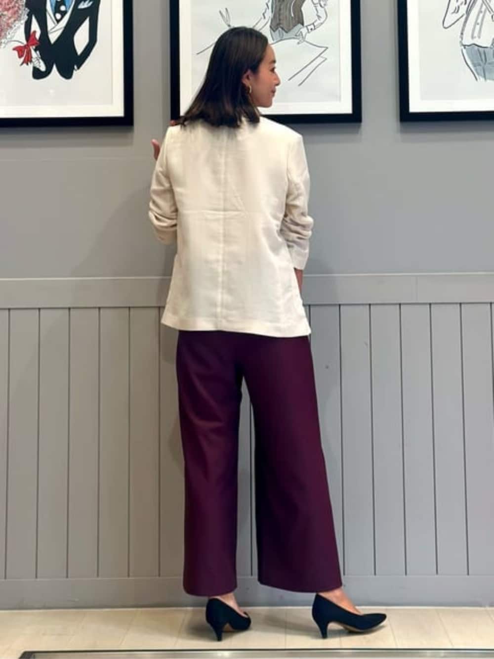 パープル系のスラックス、ホワイト系のテーラードジャケットを着用したレディースの冬コーディネートの2枚目の写真