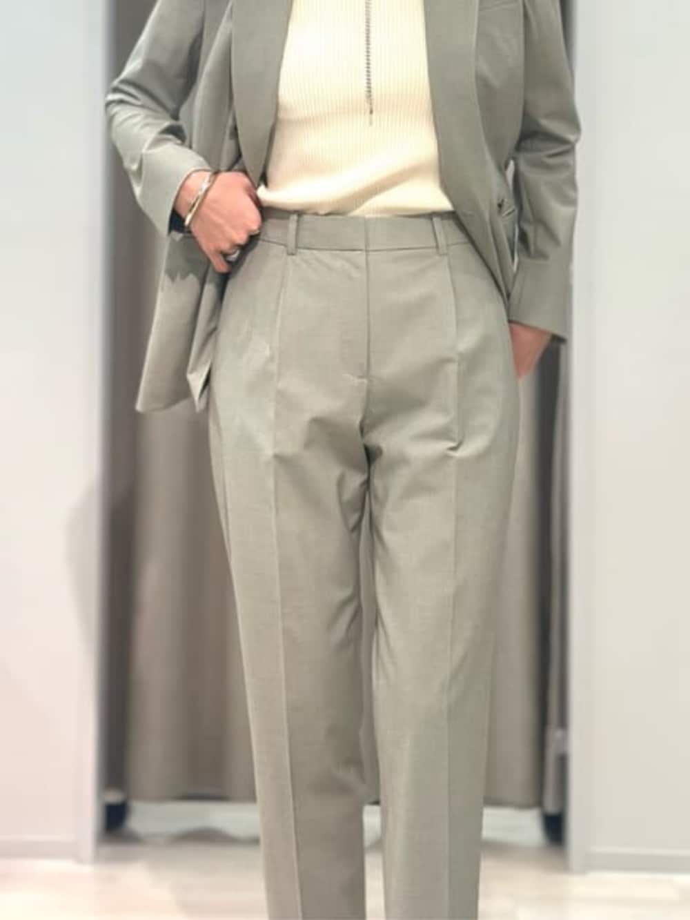 ベージュ系のニット/セーター、グリーン系のテーラードジャケット、グリーン系のスラックスを着用したレディースの冬コーディネートの9枚目の写真