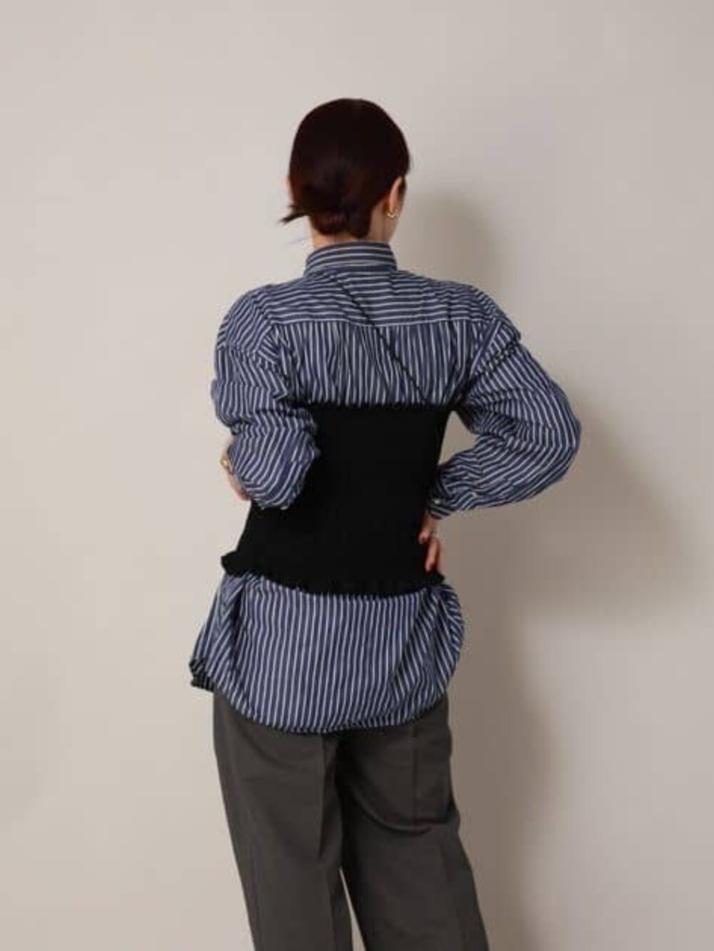 ブラック系のシャツ/ブラウス、グレー系のスラックスを着用したレディースの冬コーディネートの9枚目の写真