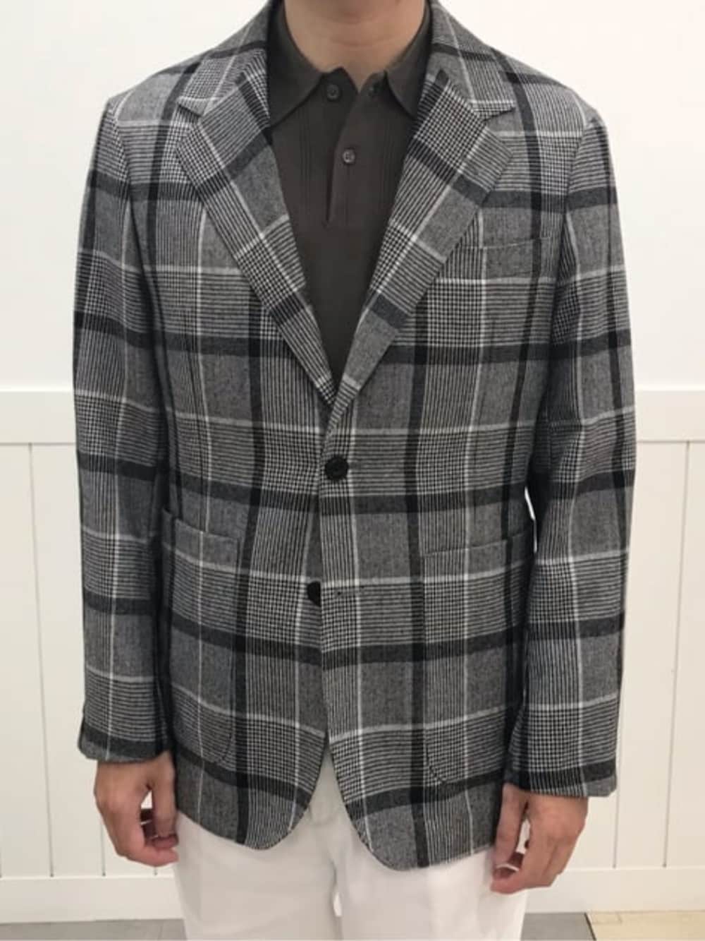 ホワイト系のスラックス、グレー系のテーラードジャケットを着用したメンズの冬コーディネートの5枚目の写真