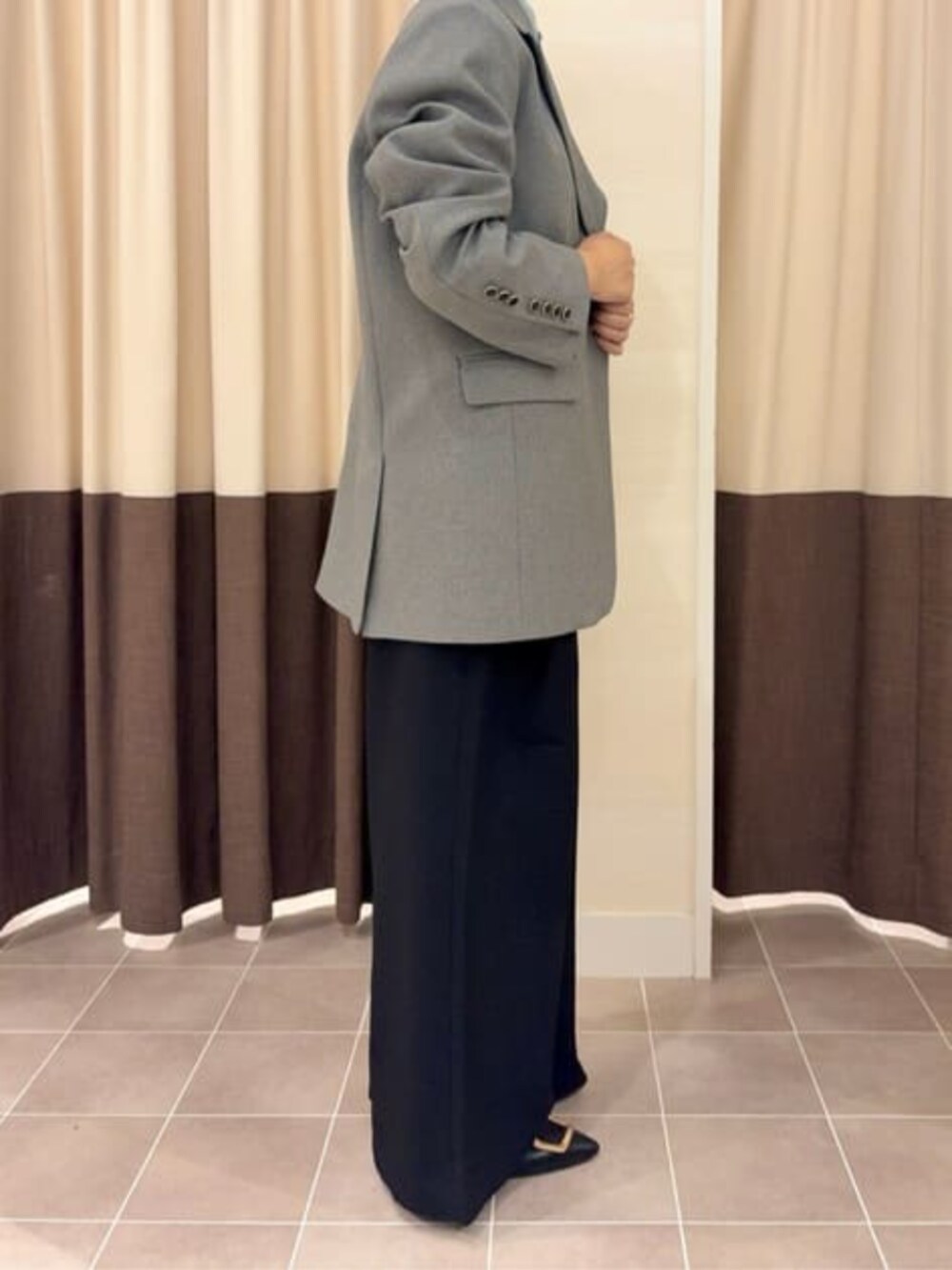 グレー系のテーラードジャケット、ブラック系のスラックス、グリーン系のシャツ/ブラウスを着用したレディースの冬コーディネートの7枚目の写真