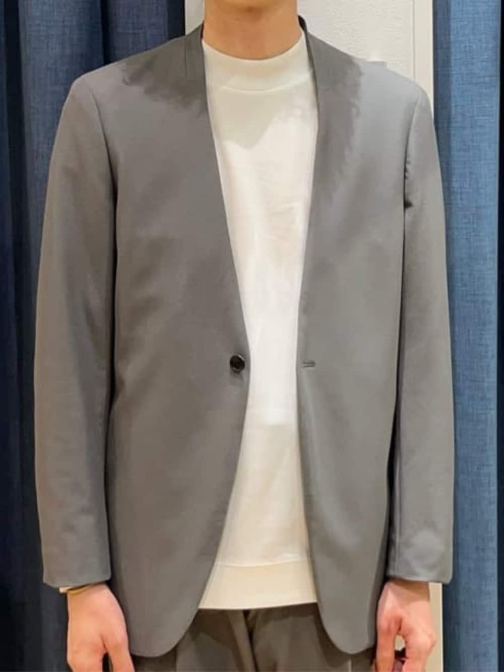 グレー系のスラックス、グレー系のテーラードジャケット、ホワイト系のTシャツ/カットソーを着用したメンズの冬コーディネートの5枚目の写真