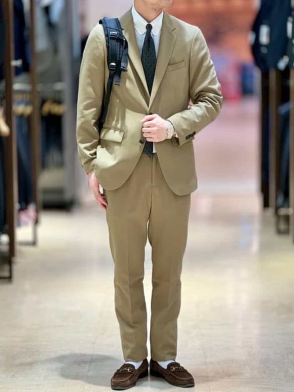 ベージュ系のスラックス、ベージュ系のテーラードジャケットを着用したメンズの春コーディネートの4枚目の写真