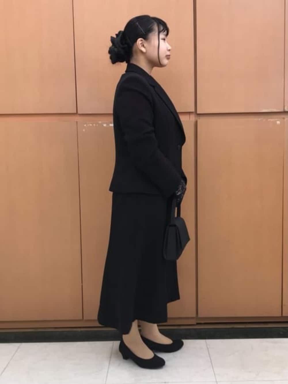 ブラック系のスーツセットを着用したレディースの冬コーディネートの8枚目の写真