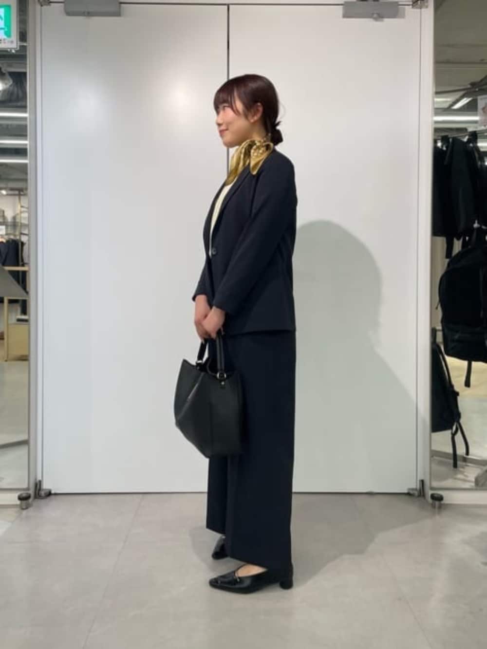 イエロー系のシャツ/ブラウス、ブルー系のテーラードジャケット、ブラック系のスラックスを着用したレディースの冬コーディネートの2枚目の写真