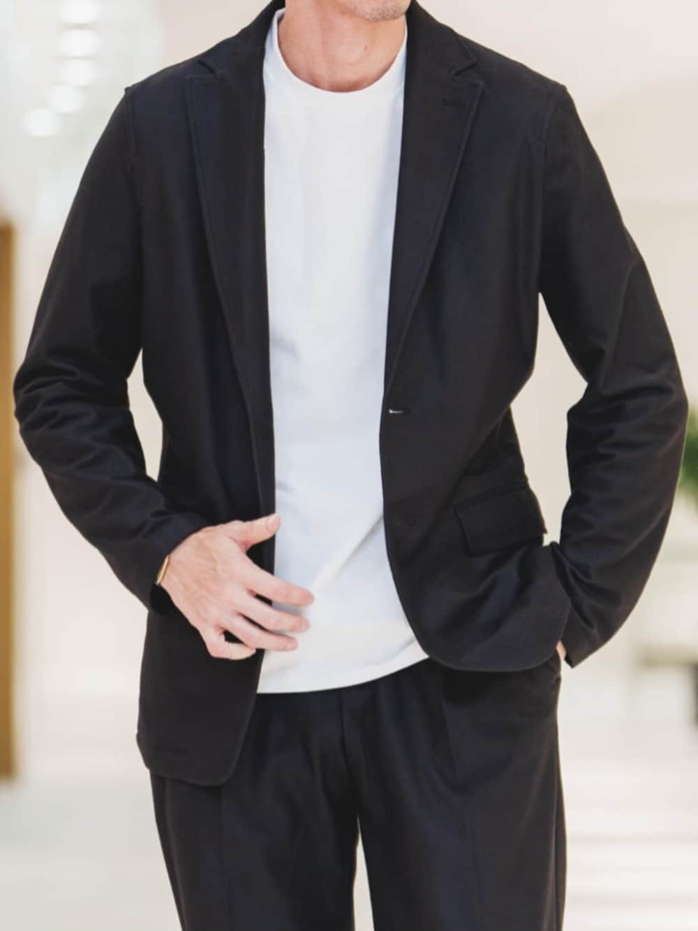 ブラック系のセットアップ、ホワイト系のTシャツ/カットソー、グレー系のバックパック/リュックを着用したメンズの冬コーディネートの4枚目の写真