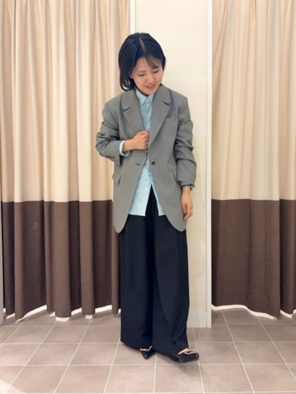 グレー系のテーラードジャケット、ブラック系のスラックス、グリーン系のシャツ/ブラウスを着用したレディースの冬コーディネートの4枚目の写真