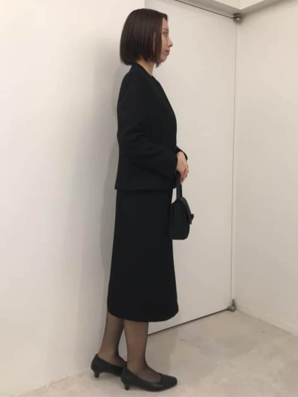 ブラック系のスーツセットを着用したレディースの冬コーディネートの3枚目の写真