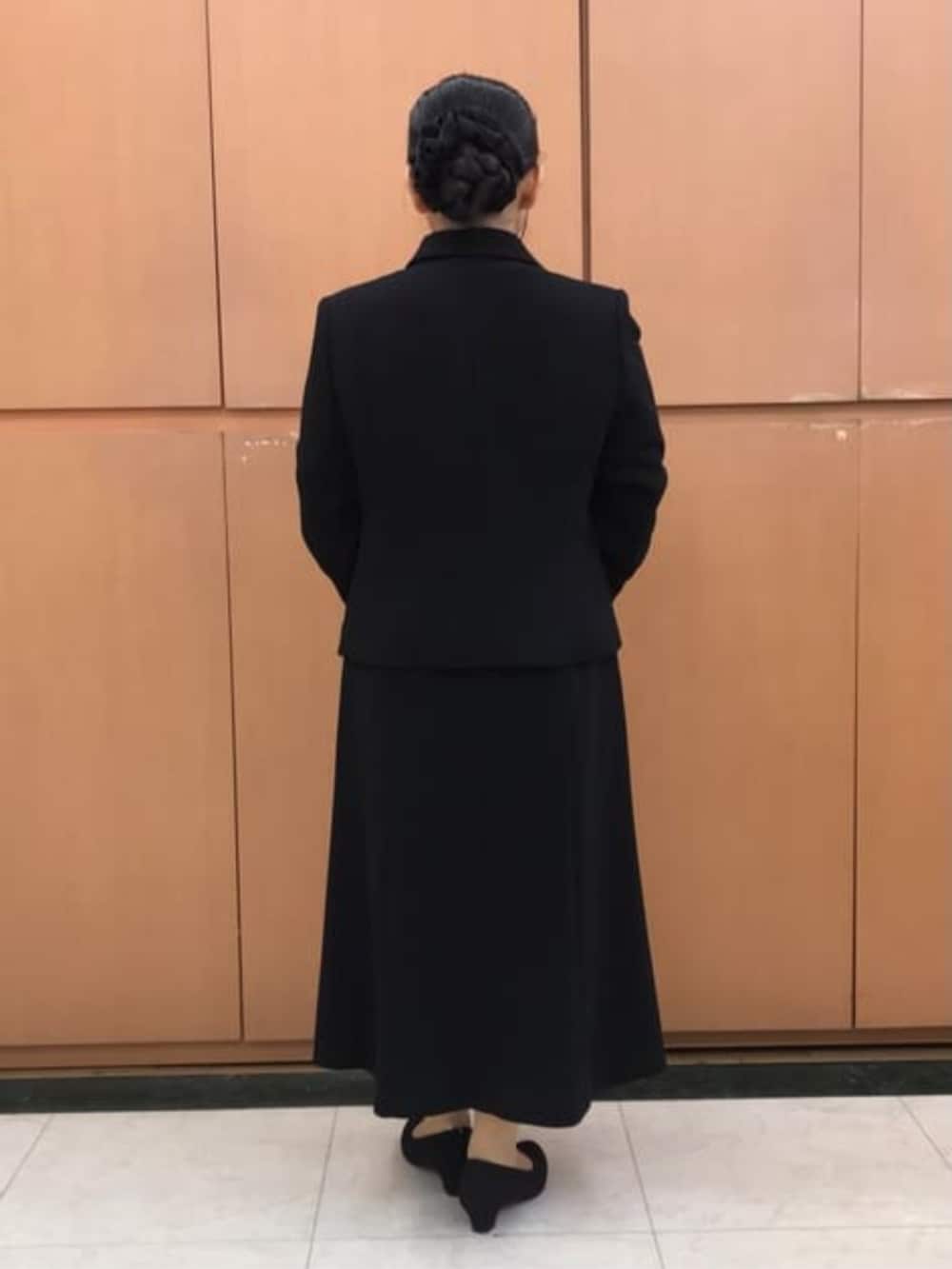 ブラック系のスーツセットを着用したレディースの冬コーディネートの2枚目の写真