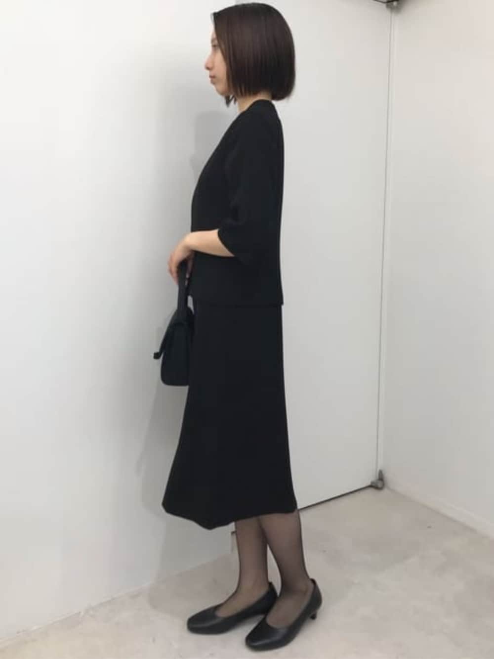 ブラック系のスーツセットを着用したレディースの冬コーディネートの6枚目の写真