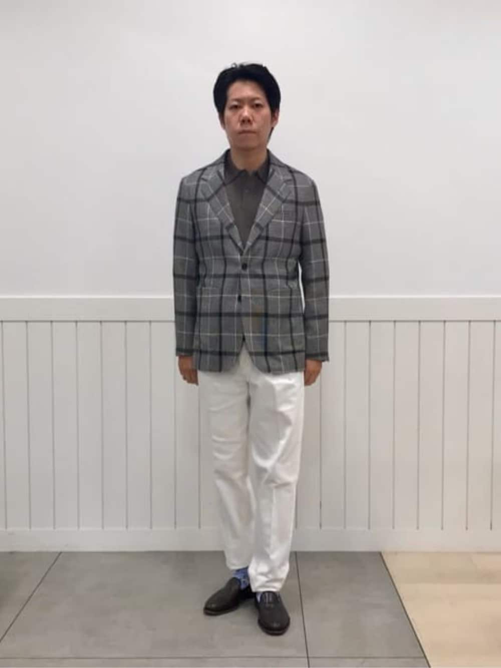 ホワイト系のスラックス、グレー系のテーラードジャケットを着用したメンズの冬コーディネートの2枚目の写真