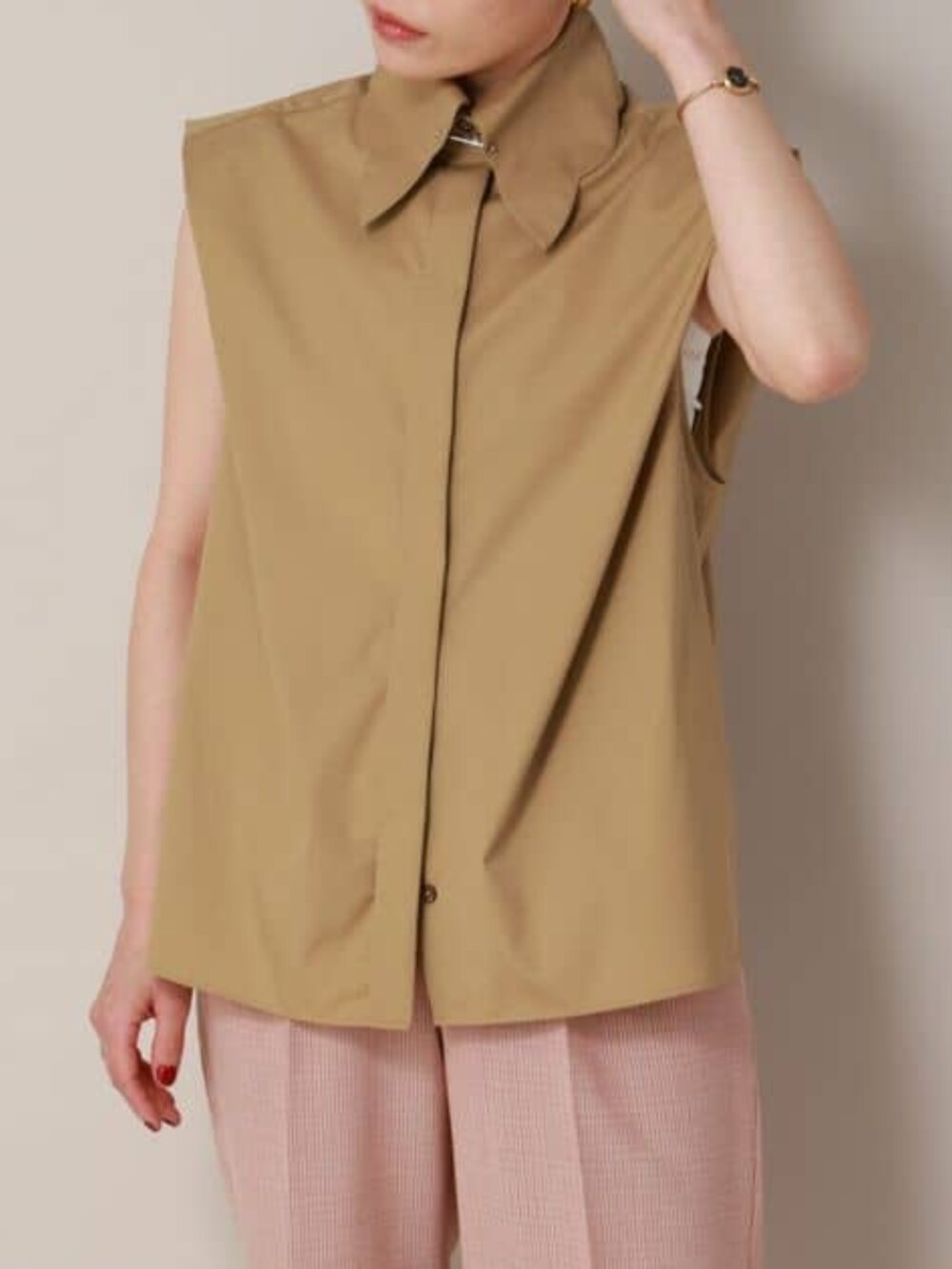 ベージュ系のシャツ/ブラウス、オレンジ系のスラックスを着用したレディースの冬コーディネートの7枚目の写真