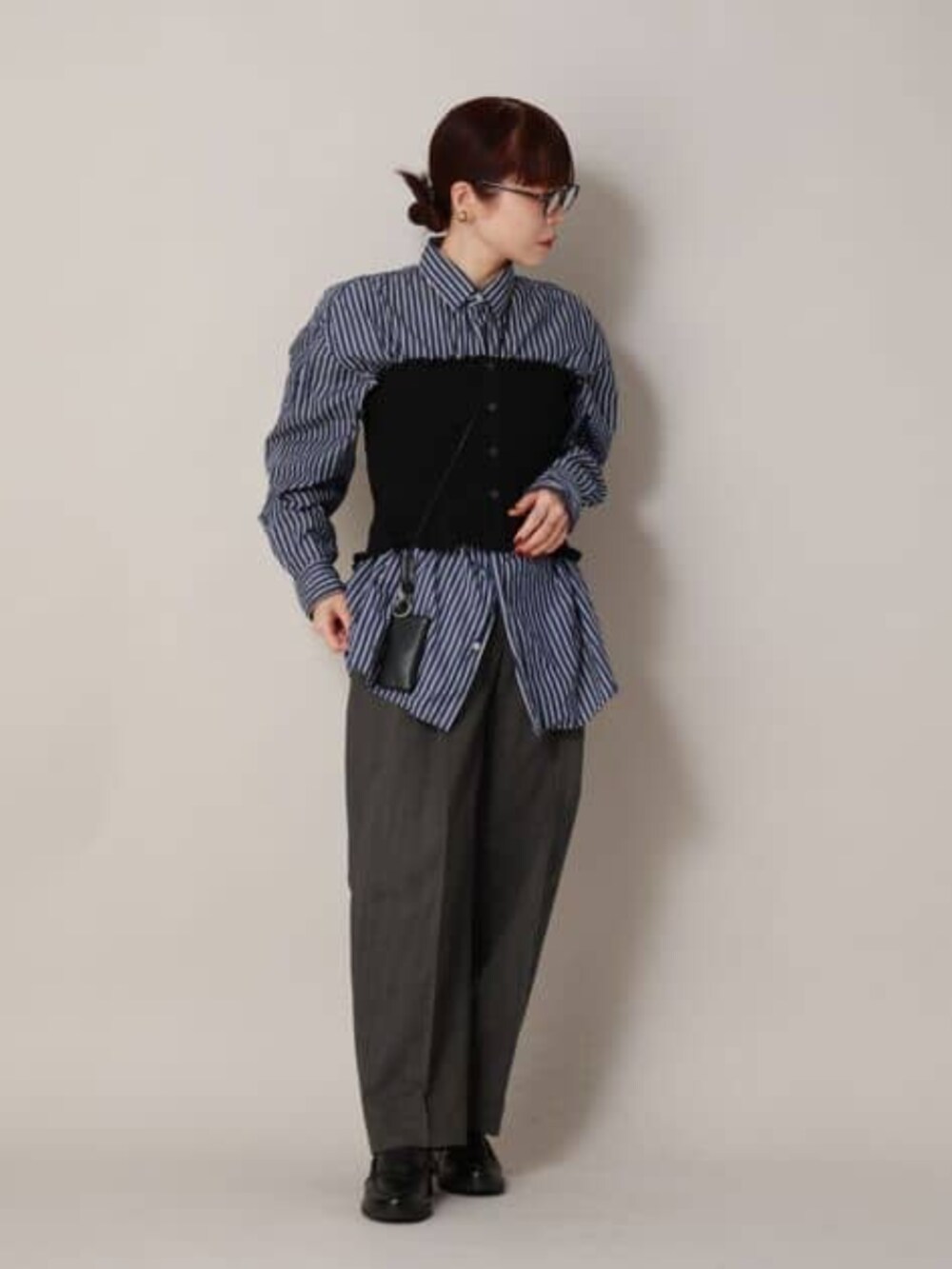 ブラック系のシャツ/ブラウス、グレー系のスラックスを着用したレディースの冬コーディネートの3枚目の写真