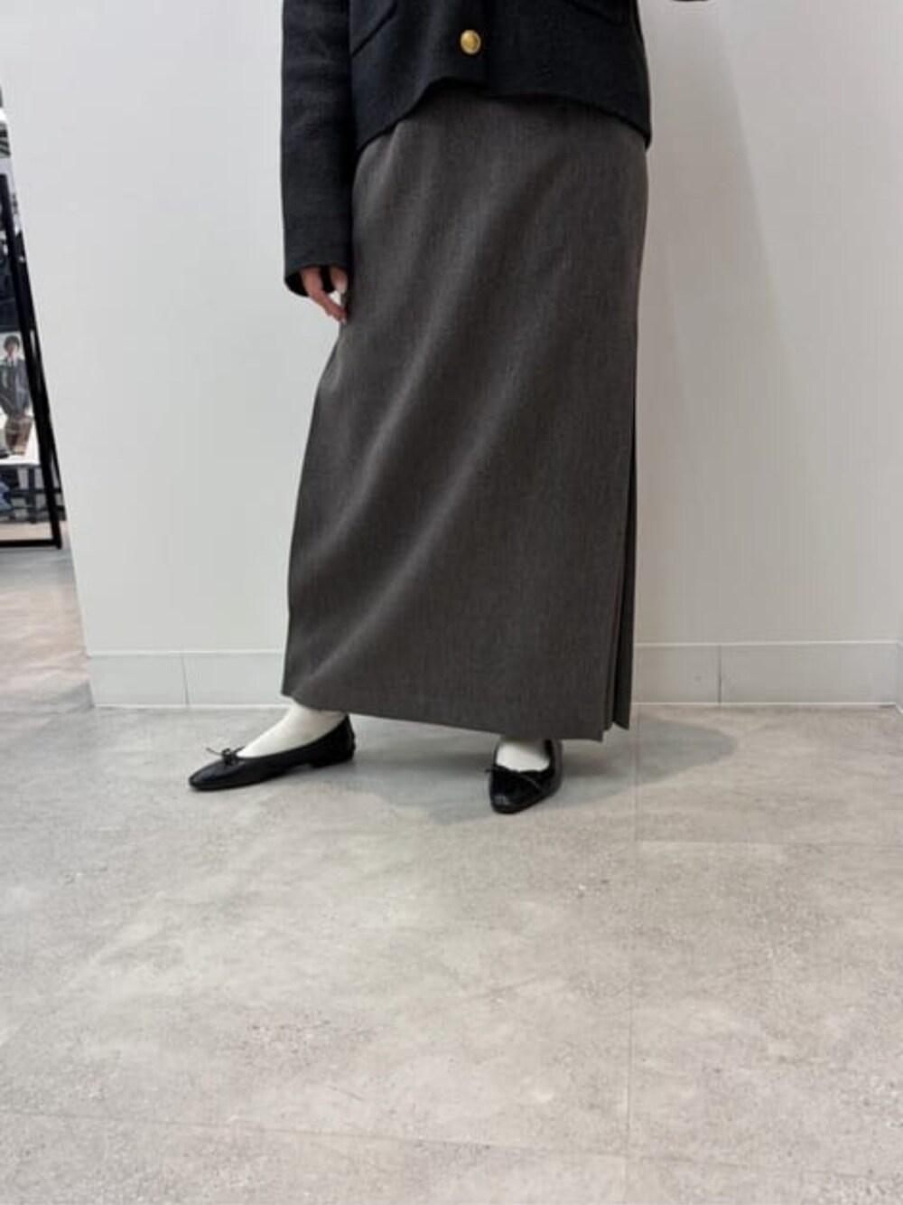 グレー系のノーカラージャケット、ベージュ系のショルダーバッグ、グレー系のスカートを着用したレディースの冬コーディネートの5枚目の写真