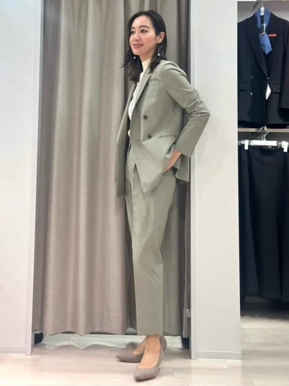 ベージュ系のニット/セーター、グリーン系のテーラードジャケット、グリーン系のスラックスを着用したレディースの冬コーディネートの4枚目の写真