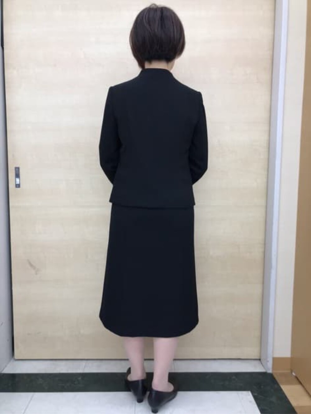 ブラック系のスーツセットを着用したレディースの冬コーディネートの7枚目の写真