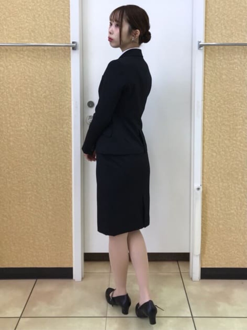 ブラック系のスーツジャケット、ブラック系のスーツスカートを着用したレディースの冬コーディネートの3枚目の写真