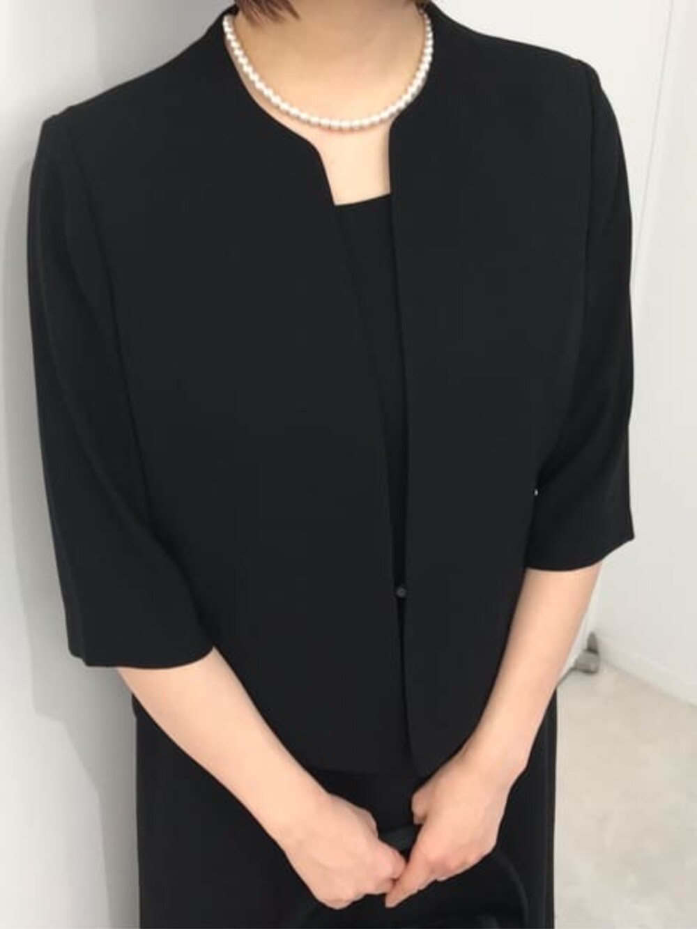 ブラック系のスーツセットを着用したレディースの冬コーディネートの7枚目の写真