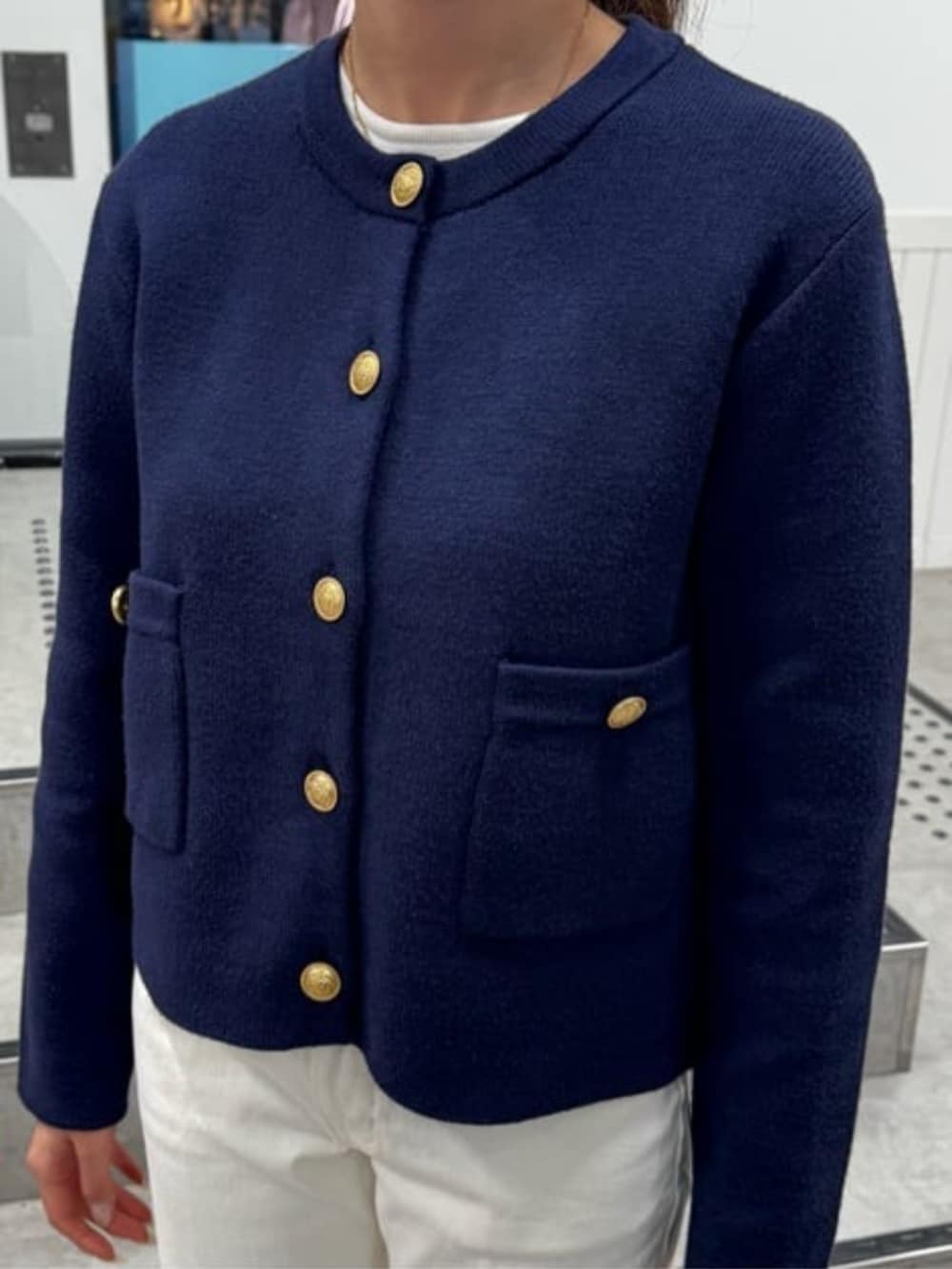 ブルー系のノーカラージャケットを着用したレディースの冬コーディネートの3枚目の写真