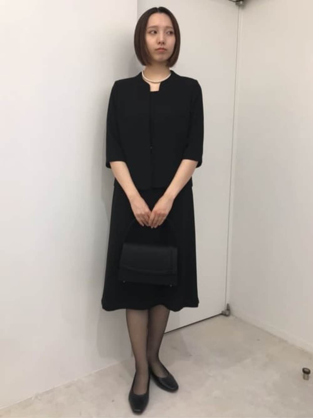 ブラック系のスーツセットを着用したレディースの冬コーディネートの5枚目の写真